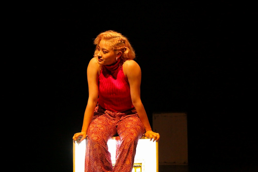 Woman with a red sweater on the stage.